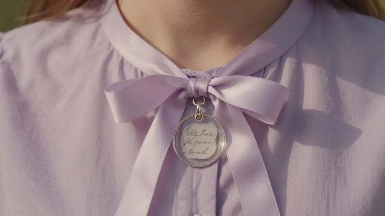 Un chouchou en soie avec un mot écrit à la main, porté comme une amulette.