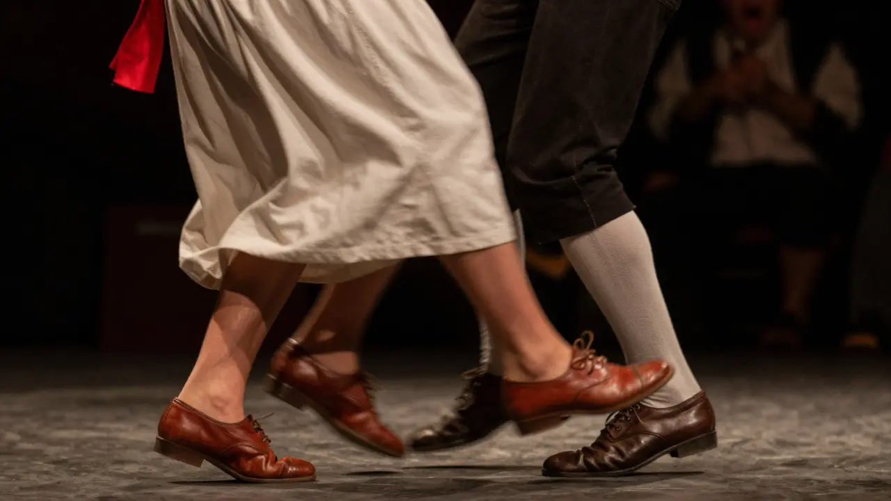 Gros plan d'un chanteur folklorique et de pieds dansant la bourrée avec émotion.